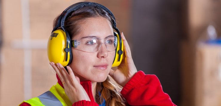 vrouw draagt gehoorbescherming op het werk